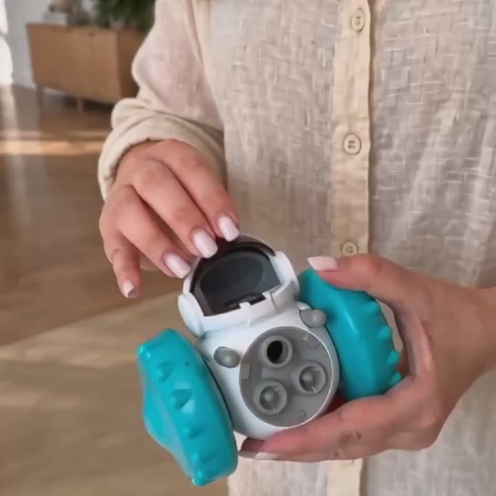 Dog playing with a rolling treat robot