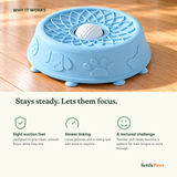 Powder-blue silicone lotus lick bowl with a raised sidewall standing on suction feet on an oak floor